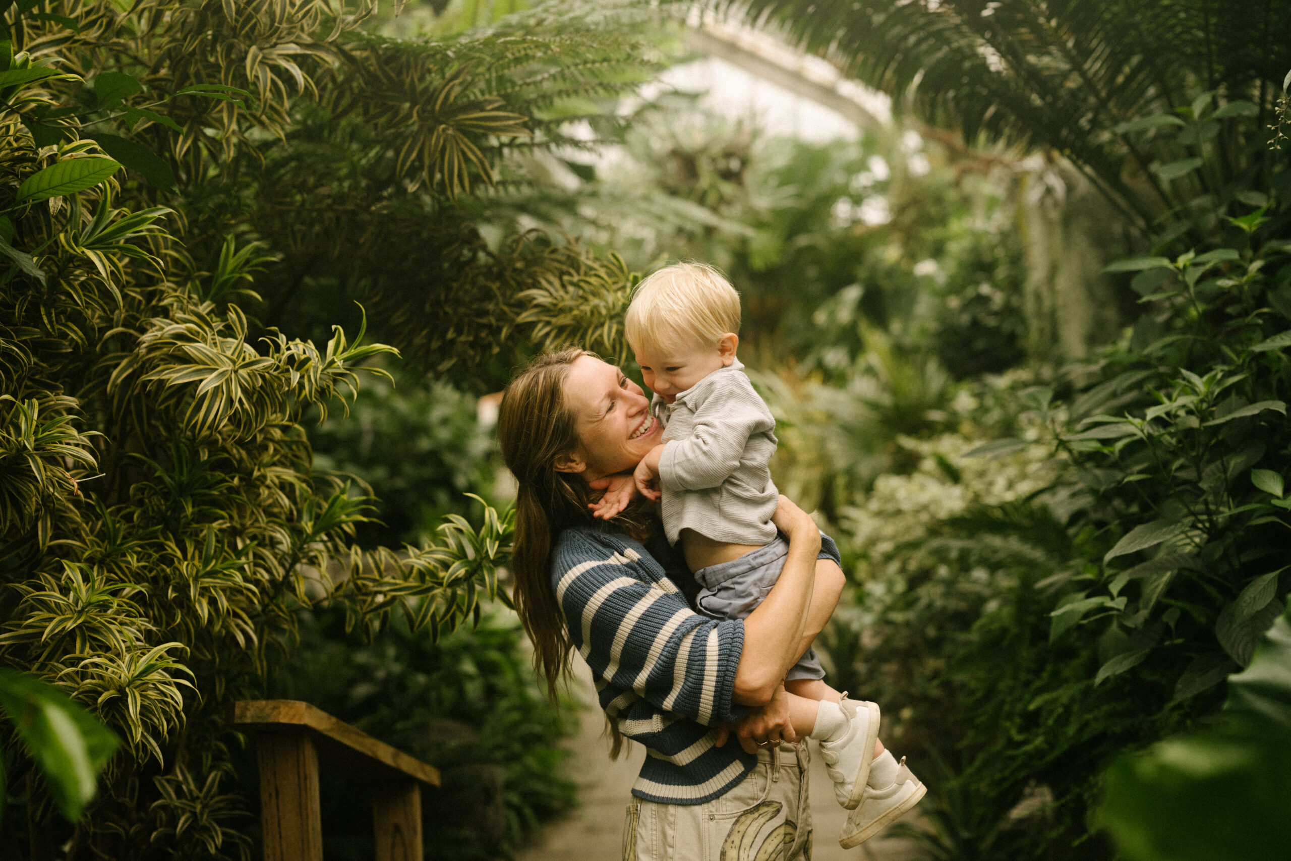 Ren Lenhof holding her baby boy in a garden laughing.